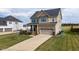 A shot of a brick and vinyl two-story house with a two car garage and a concrete driveway at 319 Brinkley Cir, Mebane, NC 27302