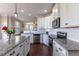 Modern kitchen boasts an island with granite countertops, stainless appliances, white cabinetry, and an open design at 319 Brinkley Cir, Mebane, NC 27302