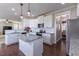 An open concept kitchen featuring white cabinets, stainless steel appliances, and granite countertops at 319 Brinkley Cir, Mebane, NC 27302