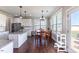 A sunlit kitchen has an island with granite countertops and stainless steel appliances, flowing into a cozy breakfast nook at 319 Brinkley Cir, Mebane, NC 27302