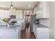 Bright white kitchen with stainless steel appliances, granite countertops, tile backsplash, and dark wood floors at 319 Brinkley Cir, Mebane, NC 27302