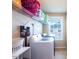 Bright laundry room features a front load washer, storage shelves, and window for natural light at 319 Brinkley Cir, Mebane, NC 27302