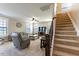 Living room with staircase, plush carpet, cozy seating, and large windows that offer lots of natural light at 319 Brinkley Cir, Mebane, NC 27302