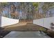 Fenced backyard with a mix of wooded areas and open space and includes a small patio at 3408 Dropseed Dr, Apex, NC 27502