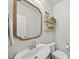 Stylish half-bathroom featuring a modern sink, decorative mirror, and floating shelves at 3408 Dropseed Dr, Apex, NC 27502