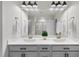 Bright bathroom with a double sink vanity, decorative lights, and a glass enclosed shower in the background at 3408 Dropseed Dr, Apex, NC 27502