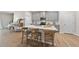 Modern kitchen featuring gray cabinets, stainless steel appliances, and a large island with bar stool seating at 3408 Dropseed Dr, Apex, NC 27502