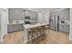 Spacious kitchen with gray cabinets, large island with bar seating, and stainless steel refrigerator at 3408 Dropseed Dr, Apex, NC 27502