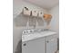 Bright laundry room with modern appliances including a washer and dryer, with shelving above at 3408 Dropseed Dr, Apex, NC 27502