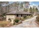 Beautiful single-story home with a brick garage, and a gravel driveway surrounded by trees at 3514 Ridge Rd, Durham, NC 27705