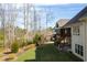 Backyard featuring a spacious deck, patio, lush green lawn, and wooded area for privacy at 363 Rolling Meadows Ln, Chapel Hill, NC 27517