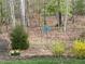 A backyard featuring garden art, yellow daffodils, and forsythia in a natural wooded setting at 363 Rolling Meadows Ln, Chapel Hill, NC 27517