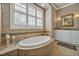 An elegant bathroom featuring a standalone tub, tile surround, and a large shuttered window at 363 Rolling Meadows Ln, Chapel Hill, NC 27517