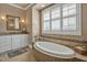 Serene bathroom featuring a standalone tub, tile surround, and large shuttered window at 363 Rolling Meadows Ln, Chapel Hill, NC 27517