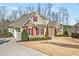 A beautifully landscaped home featuring a stone facade, red shutters and manicured shrubs at 363 Rolling Meadows Ln, Chapel Hill, NC 27517