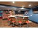Basement wet bar area with wood paneling, counter seating, and sports-themed wall decorations at 3633 Jordan Shires Dr, New Hill, NC 27562