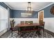 Cozy dining room featuring a rustic wooden table with bench seating, wainscoting, and modern lighting at 3633 Jordan Shires Dr, New Hill, NC 27562