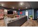 Spacious basement living room with wood ceiling, brick accent wall, and comfortable seating arrangement at 3633 Jordan Shires Dr, New Hill, NC 27562