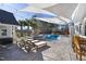 A pool area with a hot tub, lounge chairs, a sun shade, and string lights at 3633 Jordan Shires Dr, New Hill, NC 27562