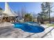 Outdoor pool area featuring lounge chairs, a pool, hot tub, sunshades, and manicured landscaping at 3633 Jordan Shires Dr, New Hill, NC 27562