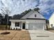 Charming new construction home featuring a two-car garage, craftsman-style details, and a well-manicured front lawn at 394 Springtooth Dr, Zebulon, NC 27597