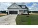 New construction shows a charming one-story home with white siding and a well-manicured green lawn at 394 Springtooth Dr, Zebulon, NC 27597