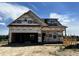 New construction home featuring a two-story design, attached garage, and builder's wrap visible on the exterior walls at 394 Springtooth Dr, Zebulon, NC 27597