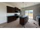 Modern kitchen with dark wood cabinets, a center island, and stainless steel appliances at 394 Springtooth Dr, Zebulon, NC 27597