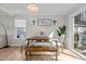 Bright dining area features a wooden table, bench, and large windows with a view to the backyard at 402 Homestead Park Dr, Apex, NC 27502