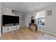 Comfortable living room area with hardwood floors, large screen television, and stairway access to other floors at 402 Homestead Park Dr, Apex, NC 27502