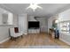 Cozy living room space featuring hardwood floors, a ceiling fan, and access to the breakfast bar at 402 Homestead Park Dr, Apex, NC 27502