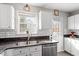 Bright kitchen area with stainless steel appliances, granite counters and white cabinets at 408 E Maple Ave, Holly Springs, NC 27540