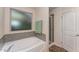 Bathroom featuring tub, shower, and tiled accents by a bright window at 410 Pintail Ct, Durham, NC 27704