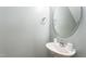 Clean half-bathroom with pedestal sink, decorative oval mirror, and chrome fixtures at 410 Pintail Ct, Durham, NC 27704