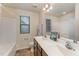 Well-lit bathroom with double sinks, bathtub, and vanity with generous counter space at 410 Pintail Ct, Durham, NC 27704