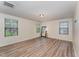 Bright bedroom with wood-look flooring, three windows, and a neutral wall color at 410 Pintail Ct, Durham, NC 27704