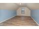 Attic bedroom featuring vaulted ceilings, wood-look floors, and ample natural light at 410 Pintail Ct, Durham, NC 27704