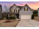 Charming two-story home with vinyl siding, mature landscaping, and a two-car garage at sunset at 410 Pintail Ct, Durham, NC 27704