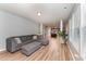 Open-concept living room with a large gray sofa, hardwood floors, and views of the kitchen at 410 Pintail Ct, Durham, NC 27704
