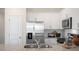Close up of a modern kitchen featuring granite countertops, stainless steel appliances, and white cabinets at 416 Belgian Red Way, Wake Forest, NC 27587
