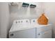 Neat laundry area features a white Whirlpool washer/dryer, practical shelf and charming woven basket at 416 Belgian Red Way, Wake Forest, NC 27587