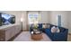 Inviting living room with plush blue sofa, stylish decor, and large windows offering natural light at 416 Belgian Red Way, Wake Forest, NC 27587