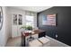 Stylish office with a rustic desk, a white bookshelf, a large American flag art piece, and a bright window at 416 Belgian Red Way, Wake Forest, NC 27587