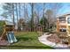 Well-maintained backyard with a shed, playground, and manicured lawn at 4228 Bibleway Ct, Holly Springs, NC 27540