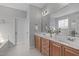 Elegant bathroom featuring a double sink vanity with wooden cabinets, and a large mirror and modern fixtures at 4228 Bibleway Ct, Holly Springs, NC 27540