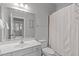Neutral bathroom boasts a large mirror, a white sink vanity, toilet, towel rack and shower with curtain at 4228 Bibleway Ct, Holly Springs, NC 27540