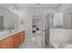 Bathroom featuring a double vanity with granite countertop, glass-enclosed shower, and access to the main bedroom at 4228 Bibleway Ct, Holly Springs, NC 27540