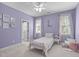 Bright bedroom features a pink bed frame, lilac walls, and ample natural light from large windows at 4228 Bibleway Ct, Holly Springs, NC 27540