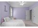 This purple bedroom has a ceiling fan, light-filled windows, and a cozy decor at 4228 Bibleway Ct, Holly Springs, NC 27540
