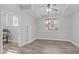 Bright bedroom features wood-look floors, neutral walls, a ceiling fan, a window, and an attached office space at 4228 Bibleway Ct, Holly Springs, NC 27540